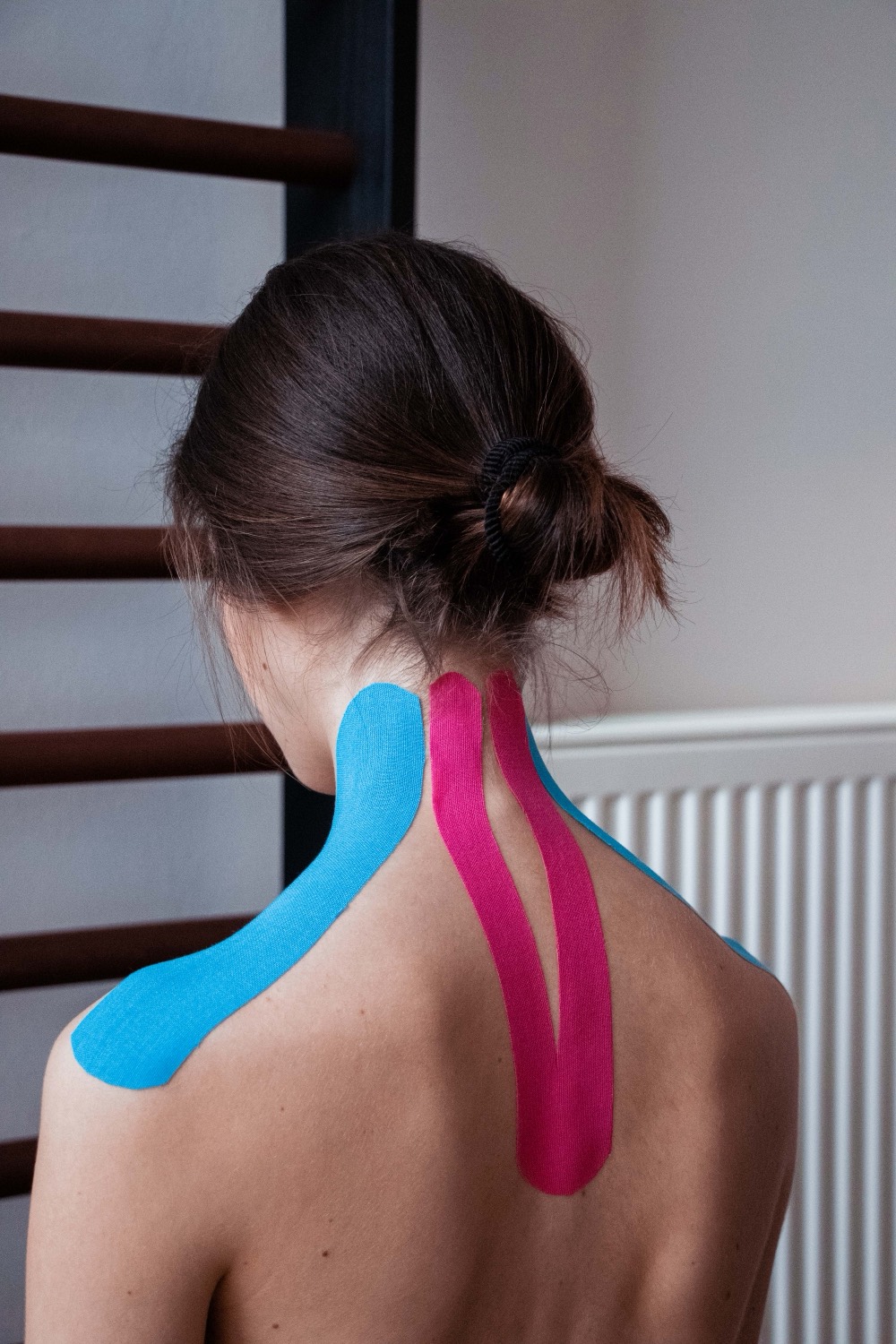 Mit Kinesiotape versorgter Nacken einer Patientin der Praxis MediKuss